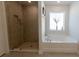Beautiful bathroom featuring a glass enclosed shower and soaking tub under a bright window at 5001 Sw 91St Pl, Ocala, FL 34476