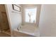 Bathroom featuring a soaking tub under a bright window with a glass enclosed shower at 5001 Sw 91St Pl, Ocala, FL 34476