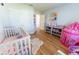 Bright bedroom boasts wood floors, a play tent, and a coordinated pink decor scheme at 5001 Sw 91St Pl, Ocala, FL 34476