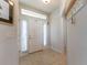 Bright entryway featuring neutral tile, a front door with sidelights, and storage hooks at 5001 Sw 91St Pl, Ocala, FL 34476
