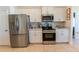 Bright kitchen featuring stainless steel appliances, white cabinetry, and granite countertops at 5001 Sw 91St Pl, Ocala, FL 34476