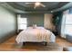 Beautiful main bedroom with a ceiling fan, wood flooring and decorative headboard at 5001 Sw 91St Pl, Ocala, FL 34476