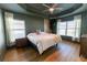 Serene bedroom with dark-green walls, tray ceiling, natural light, and luxury vinyl plank flooring at 5001 Sw 91St Pl, Ocala, FL 34476