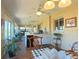 Dining area with a view of the bar, kitchen, and sitting area with hardwood floors and ample sunlight at 5291 Nw 20 Pl, Ocala, FL 34482