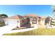 Inviting home featuring a well-manicured lawn, arched entryway, and an attached two-car garage at 5291 Nw 20 Pl, Ocala, FL 34482