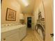 Bright laundry room featuring a washer, dryer, built-in cabinets, and an elegant decorative print of the Eiffel Tower at 5291 Nw 20 Pl, Ocala, FL 34482