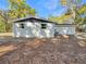 Back of white minimalist single-story house showing siding, windows, and backyard at 5311 Nw 27Th Ave, Ocala, FL 34475