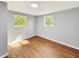A bright bedroom is shown featuring two windows, wood floors, and neutral paint throughout at 5311 Nw 27Th Ave, Ocala, FL 34475