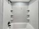 Shower and tub combination features white subway tile and built-in shelving at 5311 Nw 27Th Ave, Ocala, FL 34475