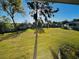 Scenic backyard view through a screened window, highlighting lush green space and community buildings at 584 Bahia Cir # B, Ocala, FL 34472