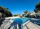 Community swimming pool featuring lounge chairs, sun umbrellas, a fence and lush trees at 584 Bahia Cir # B, Ocala, FL 34472