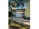 Community walkway featuring covered area with pool access, with landscaping and a trash receptacle at 584 Bahia Cir # B, Ocala, FL 34472
