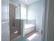 Bright bathroom boasts a shower and a separate soaking tub with tiled walls at 6138 Sw 89Th Lane Rd, Ocala, FL 34476