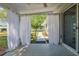 View of the covered patio with white curtains overlooking the backyard of the home at 6398 Sw 108Th St, Ocala, FL 34476