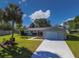 Charming single-story home with a well-manicured lawn, palm tree, and a paved driveway leading to the garage at 6398 Sw 108Th St, Ocala, FL 34476