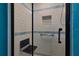 This modern shower design includes white tiles with blue stripes, seating, and a glass door at 6398 Sw 108Th St, Ocala, FL 34476