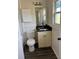 Bathroom showcasing a vanity with dark countertop and updated toilet and flooring at 6725 Nw 14Th Ave, Ocala, FL 34475