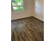A bright bedroom features wood-look vinyl floors and a window view at 6725 Nw 14Th Ave, Ocala, FL 34475