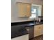 A view of the kitchen sink, countertop, window, and painted cabinets at 6725 Nw 14Th Ave, Ocala, FL 34475