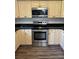 Bright kitchen featuring stainless steel appliances, wood grain flooring, and painted cabinets at 6725 Nw 14Th Ave, Ocala, FL 34475