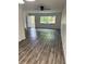 Living room with natural light, wood grain flooring, and access to the front porch at 6725 Nw 14Th Ave, Ocala, FL 34475