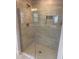 Modern tiled shower featuring a glass enclosure and convenient built-in shelving at 71 Nw 42Nd Pl, Ocala, FL 34475