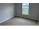 A cozy bedroom features plush carpeting, a window letting in natural light, and neutral paint at 71 Nw 42Nd Pl, Ocala, FL 34475