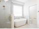 Bathroom with a glass shower, stand alone tub, and a window for natural light at 8214 Nw 17Th Cir, Ocala, FL 34475