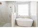 Bathroom featuring a glass shower, stand alone tub, and natural light at 8214 Nw 17Th Cir, Ocala, FL 34475