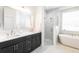 Elegant bathroom with a double sink vanity, glass shower, and stand alone tub at 8214 Nw 17Th Cir, Ocala, FL 34475