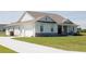 A beautifully landscaped exterior view of the home with a driveway and lush green lawn at 8214 Nw 17Th Cir, Ocala, FL 34475