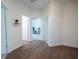 Hallway with hard wood flooring and three doors leading into rooms, including an office at 8214 Nw 17Th Cir, Ocala, FL 34475