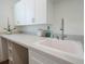 Bright laundry room with white cabinetry, a sink, and ample counter space, creating a functional area at 8214 Nw 17Th Cir, Ocala, FL 34475