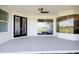 Covered patio with a ceiling fan, showcasing sliding glass doors for indoor-outdoor living at 8214 Nw 17Th Cir, Ocala, FL 34475