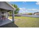 Covered patio area with chairs overlooking a large, fenced backyard offering privacy at 8216 Sw 60Th Ter, Ocala, FL 34476