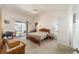 Bedroom with natural light from a sliding glass door, ceiling fan, and neutral carpet at 8216 Sw 60Th Ter, Ocala, FL 34476