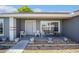 Inviting front porch with seating area, potted plants, and a decorative stone border at 8216 Sw 60Th Ter, Ocala, FL 34476