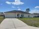 Inviting single-story home with a classic design, tidy lawn, and an attached garage for convenience at 8386 Sw 136Th Pl, Ocala, FL 34473