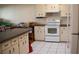 A clean kitchen with white appliances, cabinets, and white tile floors at 8569 Sw 92Nd Ln # B, Ocala, FL 34481