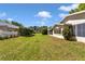 Large backyard with lush green grass, bordered by a white picket fence and mature trees at 8836 Sw 90Th Ln # B, Ocala, FL 34481