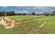 Well-maintained baseball field with green grass, dirt infield, and fencing under a bright blue sky with clouds at 8836 Sw 90Th Ln # B, Ocala, FL 34481
