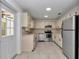 Bright kitchen features stainless steel appliances, tile floors, and updated cabinets and countertops at 8836 Sw 90Th Ln # B, Ocala, FL 34481