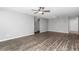 Spacious living room featuring modern ceiling fan, neutral gray walls, and stylish, dark laminate flooring at 8836 Sw 90Th Ln # B, Ocala, FL 34481