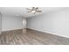 Spacious living room featuring modern ceiling fan, neutral gray walls, and stylish, dark laminate flooring at 8836 Sw 90Th Ln # B, Ocala, FL 34481