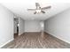 Spacious living room featuring modern ceiling fan, neutral gray walls, and stylish, dark laminate flooring at 8836 Sw 90Th Ln # B, Ocala, FL 34481