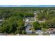 This aerial shows the property, neighboring houses, streets, and mature trees surrounding the area at 9300 Se 161St St, Summerfield, FL 34491