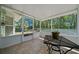 Screened-in sunroom with view of wooded backyard and tile floors at 9300 Se 161St St, Summerfield, FL 34491