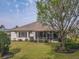 Backyard view of the screened-in lanai and lush landscaping surrounding the home at 9509 Se 124Th Loop, Summerfield, FL 34491
