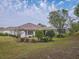Scenic backyard view showcasing a screened-in lanai and manicured garden beds at 9509 Se 124Th Loop, Summerfield, FL 34491