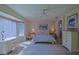 Spacious primary bedroom with bay window, matching furniture, and plush carpeting at 9509 Se 124Th Loop, Summerfield, FL 34491
